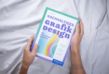 Zwei Hände halten ein Buch mit dem Titel "Nachhaltiges Grafikdesign - Das umfassende Handbuch"